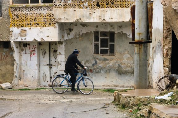 Fahrradfahrer in einer zerstörten Stadt